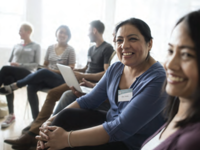 Participants sitting in a group session smiling.